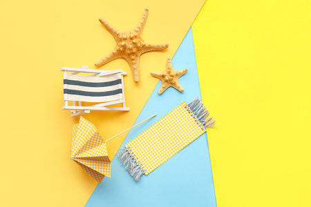 Composition with miniature deck chair, starfishes and paper umbrella on colorful background