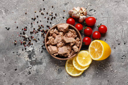Composition with delicious canned tuna in bowl on gray grunge tableの写真素材