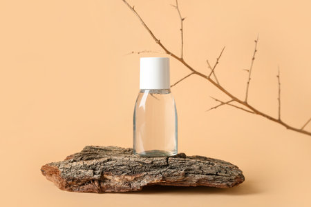 Bottle of micellar water with tree branch and bark on beige backgroundの写真素材
