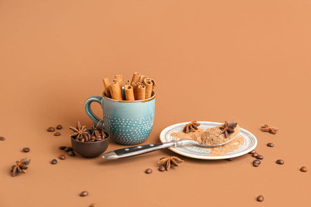 Plate with cinnamon powder, sticks, anise stars and coffee beans on color background