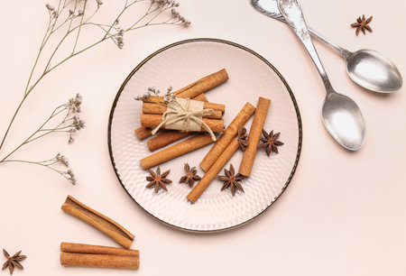 Composition with cinnamon sticks, anise stars, spoons and dried flowers on light backgroundの写真素材