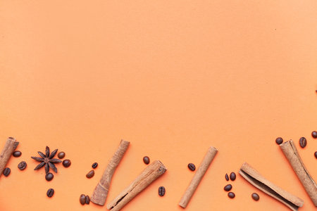 Composition with cinnamon sticks and coffee beans on color backgroundの写真素材