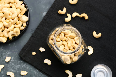 Jar with tasty cashew nuts on blue backgroundの写真素材