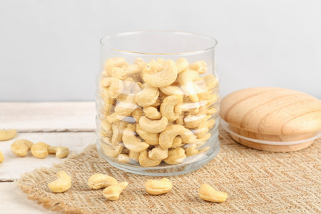 Jar with tasty cashew nuts on tableの写真素材