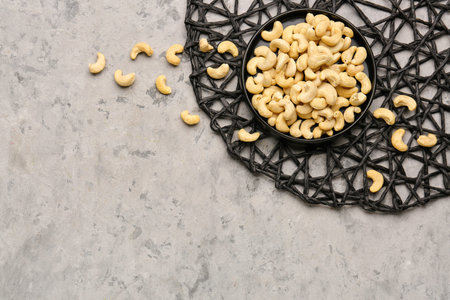 Plate with tasty cashew nuts on grunge backgroundの写真素材