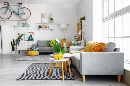 Interior of bright living room with cozy sofas and coffee table near big windowの写真素材