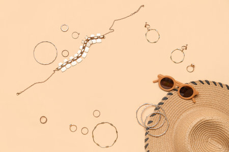 Frame made of jewelry with sunglasses and summer hat on beige backgroundの写真素材