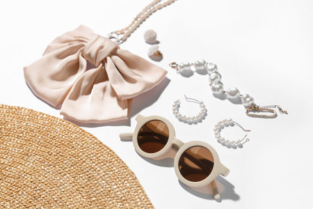 Jewelry with sunglasses and summer hat on white background, closeup