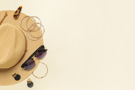 Stylish jewelry with sunglasses and summer hat on light backgroundの写真素材