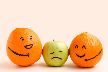 Cute orange and apple fruits on beige background. friendship day celebrationの写真素材
