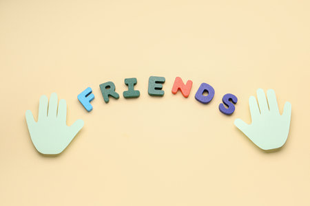 Paper palms and word FRIENDS on beige background. friendship day celebrationの写真素材