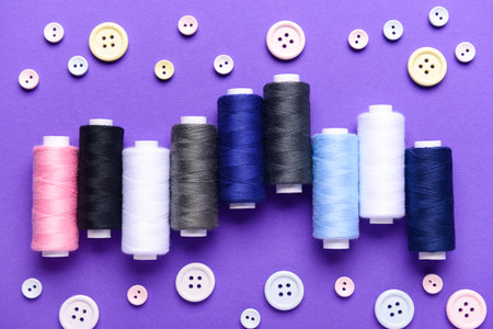 Composition with different thread spools and buttons on color backgroundの写真素材