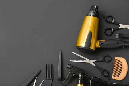 Composition with hairdressing accessories and dryer on black backgroundの写真素材