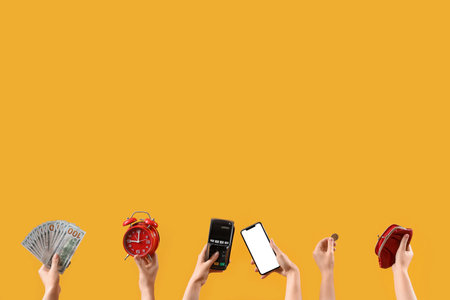 Women with money, alarm clock, payment terminal, mobile phone and wallet on yellow backgroundの写真素材