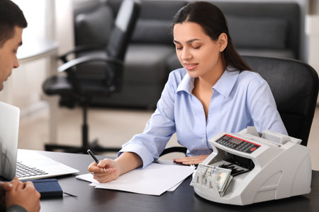 Female bank manager working with client in officeの写真素材