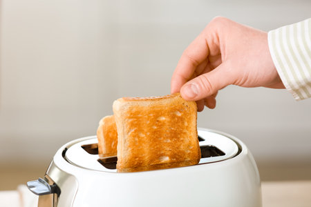 Man taking crispy bread slice from modern toaster, closeupの写真素材