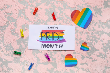 Card with text LGBTQ PRIDE MONTH, clothespins and hearts on grunge backgroundの写真素材
