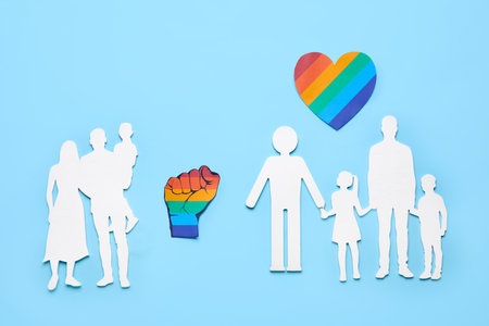 Paper family figures with heart and fist on blue background. LGBT conceptの写真素材