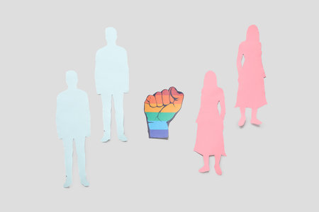 Paper fist with human figures on light background. LGBT conceptの写真素材