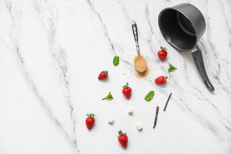 Saucepan and ingredients for preparing strawberry compote on white backgroundの写真素材