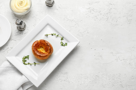 Plate with tasty Yorkshire pudding on light backgroundの写真素材