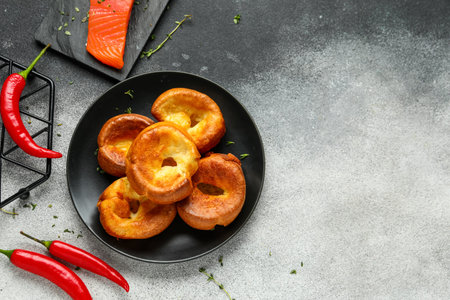 Plate with tasty Yorkshire pudding on grunge background