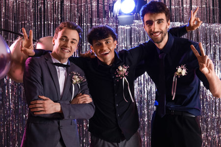 Young men showing victory gesture on prom night