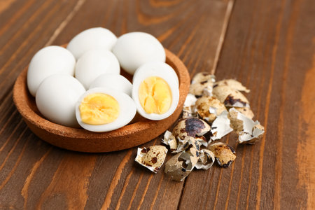 Bowl of boiled quail eggs with shells on wooden backgroundの写真素材