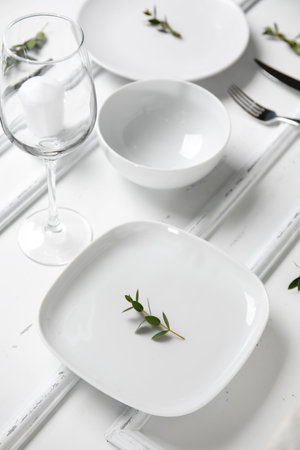Stylish table setting and candle on white wooden backgroundの写真素材
