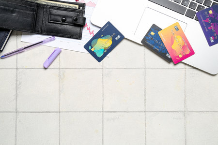 Credit cards with wallet and laptop on white tile tableの写真素材
