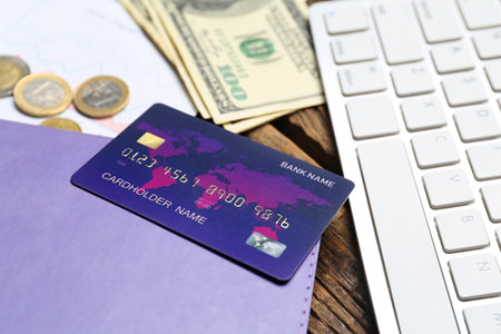 Credit cards with money and keyboard on wooden tableの写真素材