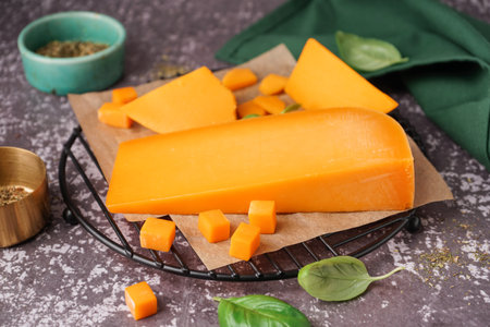 Stand with tasty cheddar cheese and herbs on grunge background, closeupの写真素材