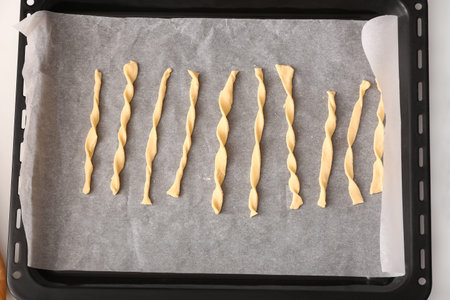 Baking tray with raw Italian Grissini, closeup