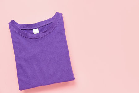 Folded purple t-shirt on pink backgroundの写真素材