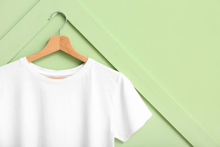 White t-shirt hanging on green wallの写真素材