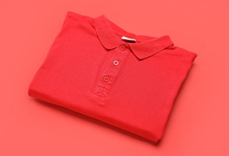 Folded red t-shirt on color backgroundの写真素材