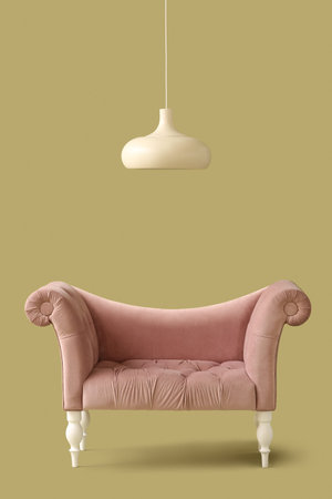 Stylish sofa and lamp on green background