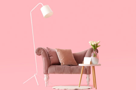 Cozy sofa on with cushions and coffee table on pink backgroundの写真素材