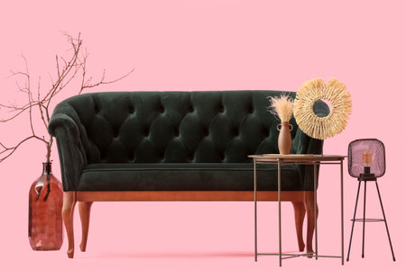 Cozy black sofa and coffee table on pink backgroundの写真素材