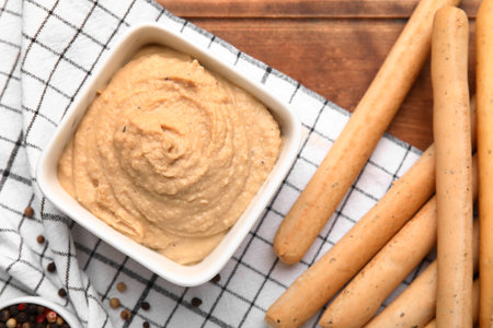 Bowl with tasty hummus and Italian Grissini on table, closeupの写真素材