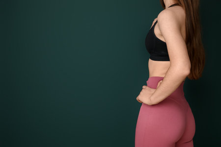 Sporty young woman in leggings on green backgroundの写真素材