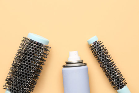 Hairdresser's brushes with spray on beige background, closeupの写真素材