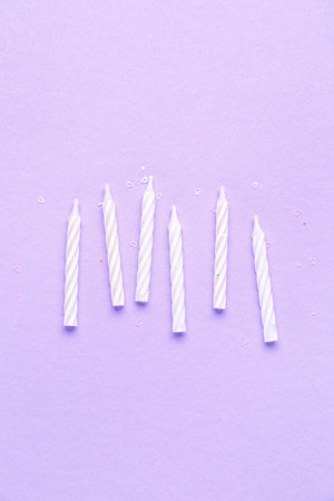 White birthday candles on lilac backgroundの写真素材