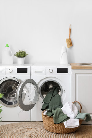 Modern washing machines with dirty clothes in laundry roomの写真素材