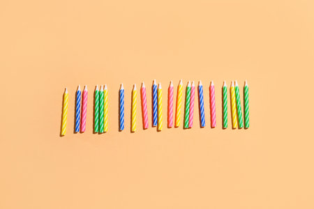 Colorful birthday candles on beige backgroundの写真素材