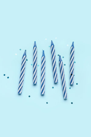 Birthday candles and glitter on blue backgroundの写真素材