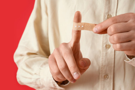 Young man with applied medical patch on red background, closeupの写真素材