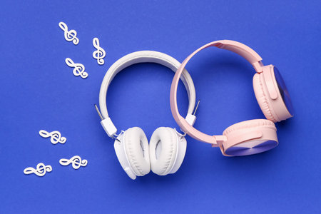 Modern headphones and music notes on blue backgroundの写真素材