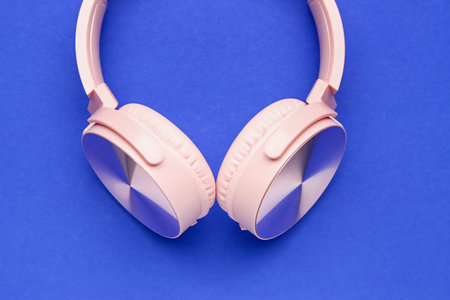 Modern pink headphones on blue backgroundの写真素材