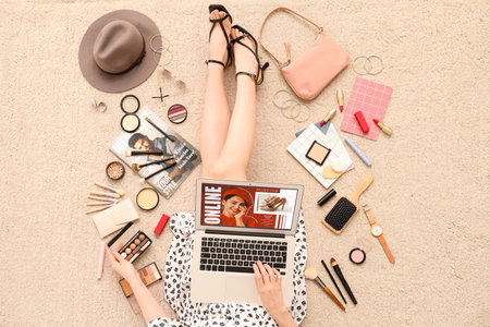 Woman with laptop and accessories shopping online on beige carpetの写真素材